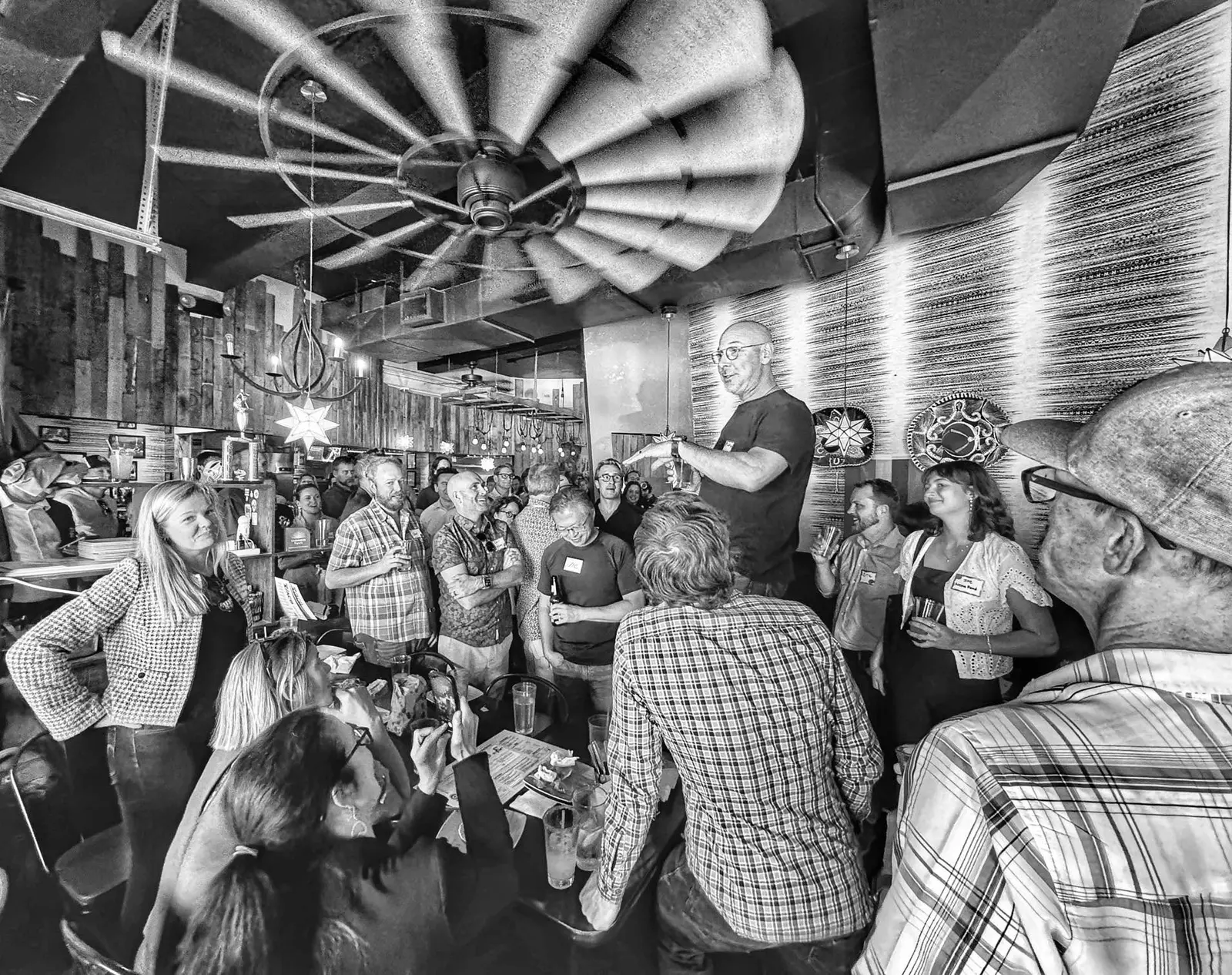man speaking at an event in crowd of people